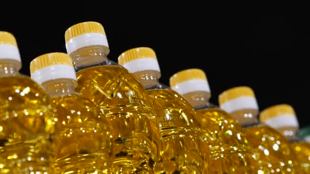 Transparenta plastflaskor fyllda med gyllene solrosolja — Stockvideo
