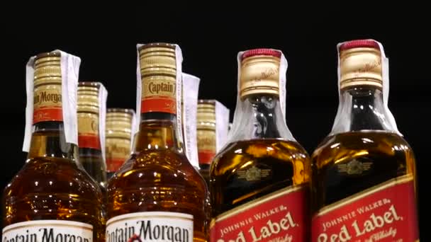 Johnnie Walker Red Label και Captain Morgan μπουκάλια ουίσκι στα ράφια των καταστημάτων — Αρχείο Βίντεο