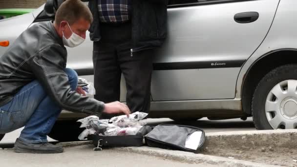 Street vendor indossare maschera viso mentre sbirciare da occhiali da lettura valigia per l'uomo — Video Stock