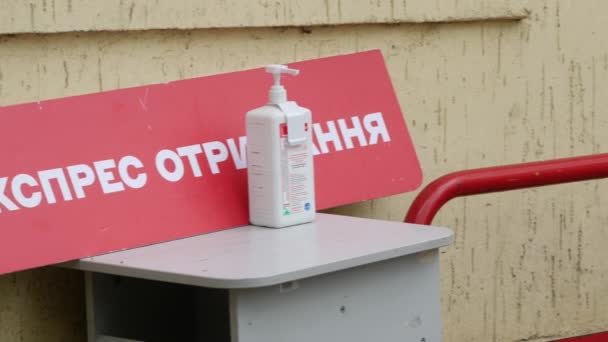 Sanitizer dispenser met alcohol antisepticum bij ingang van Nova Poshta kantoor — Stockvideo