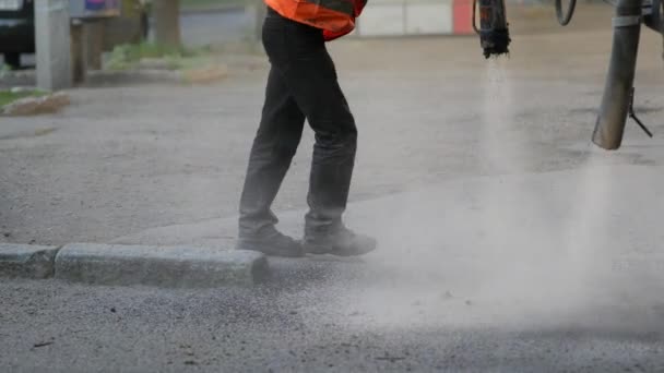 Trabalhadores realizam pequenas reparações no pavimento por pulverização de lascas de asfalto na estrada — Vídeo de Stock