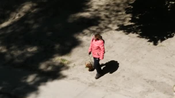 Ragazza in giacca rossa con zaino torna da una passeggiata con un cagnolino — Video Stock