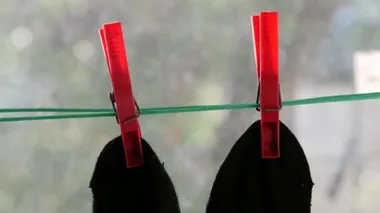 İki siyah adamın çorapları yeşil ipte kırmızı mandallarla bağlanmış..