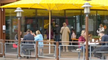 McDonald 's ziyaretçileri açık havada yemek yiyor. Popüler fast food restoranı tabelası