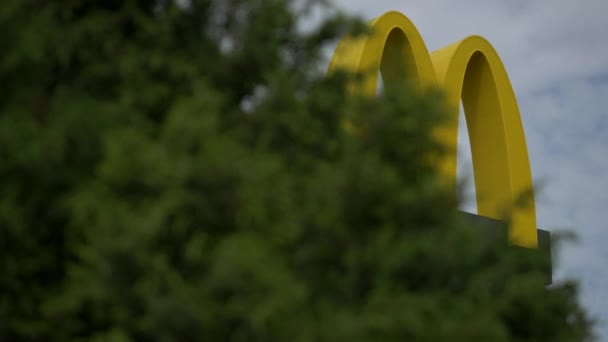 Logotipo da McDonalds. Fast-food restaurante publicidade ao ar livre de sinal amarelo no céu — Vídeo de Stock