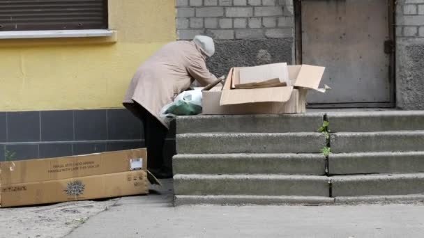 Mujer anciana en edad de jubilación en tipos de mascarilla protectora cartón corrugado — Vídeos de Stock