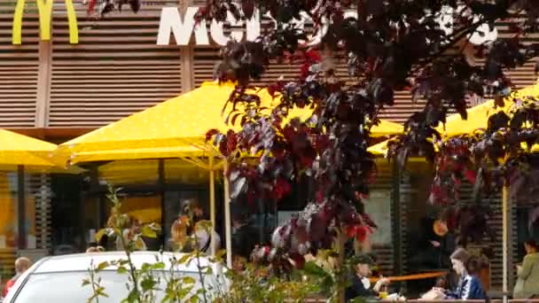 Visitantes do McDonalds comendo no espaço ao ar livre. Sinal de restaurante popular fast food — Vídeo de Stock
