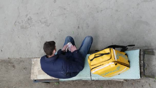 Correio de entrega GLOVO com mochila térmica amarela de marca para pedidos de clientes. — Vídeo de Stock