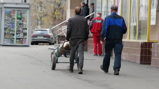 Werknemers vervoeren acetyleen en zuurstof gas tanks op de hand truck. Lasser en assistent — Stockvideo