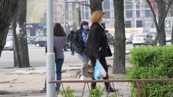 Die Menschen gehen durch die Straßen der Stadt und tragen Gesichtsmasken und Latexhandschuhe. Quarantäne — Stockvideo