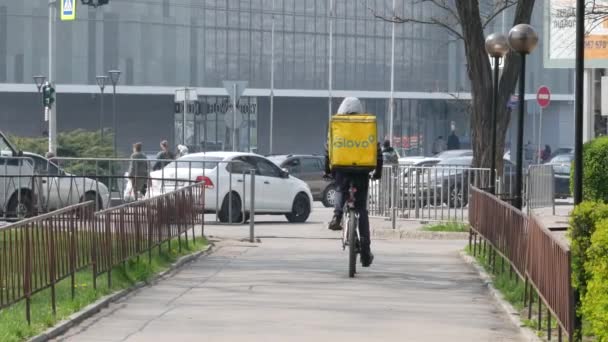 Μεταφορέας GLOVO με επώνυμη κίτρινη θερμική τσάντα για παραγγελίες πελατών — Αρχείο Βίντεο