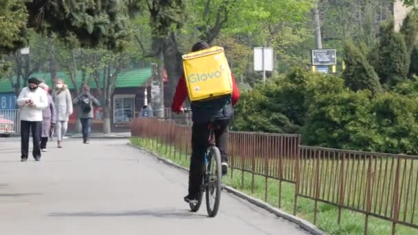 Kurier dostawy GLOVO z markowym żółtym plecakiem termicznym na zamówienie klienta — Wideo stockowe