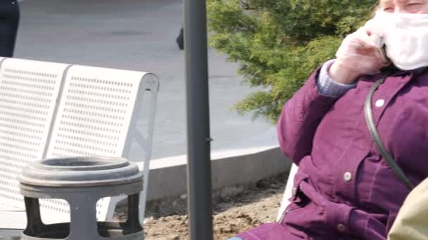 Starsza kobieta na ulicy nosi maski i lateksowe rękawiczki. Kwarantanna — Wideo stockowe