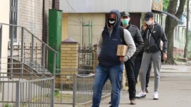 Müşteriler sosyal mesafede kuyrukta bekliyor. DIY koruyucu maskeli insanlar