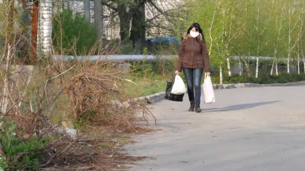 Die Menschen gehen durch die Straßen der Stadt und tragen Gesichtsmasken und Latexhandschuhe. Quarantäne — Stockvideo