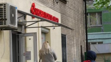 İnsanlar Nova Poshta 'nın girişine yakın bir sokakta kuyruğa giriyorlar.