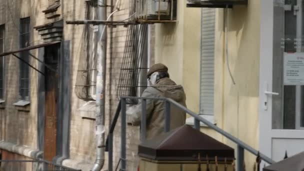 Ηλικιωμένος άνδρας φορώντας σπιτική προστατευτική μάσκα γάζας στο πρόσωπό του κατεβαίνει — Αρχείο Βίντεο
