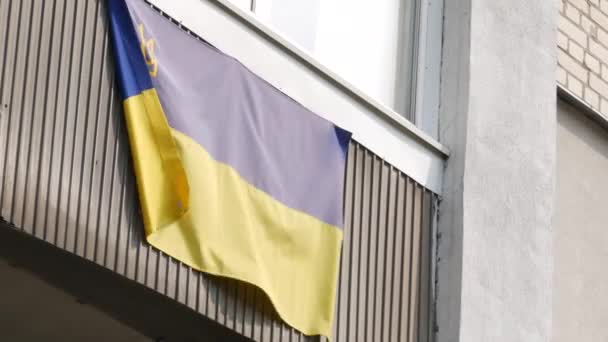 Bandeira nacional da Ucrânia é pendurada na varanda do edifício residencial e vigias — Vídeo de Stock