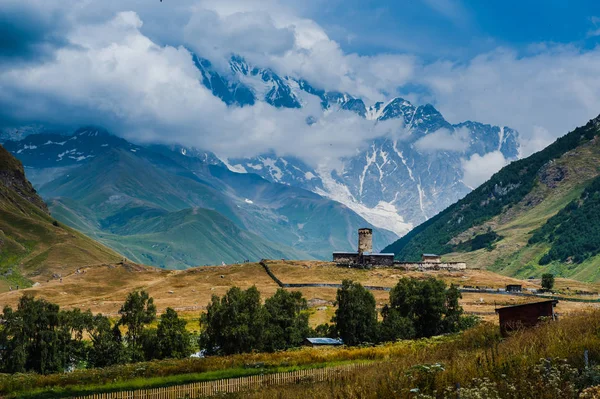 Pueblo Ushguli paisaje con enormes montañas rocosas — Foto de Stock