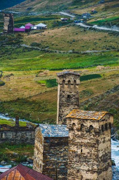 Pueblo Ushguli paisaje con enormes montañas rocosas —  Fotos de Stock