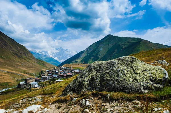 Pueblo Ushguli paisaje con enormes montañas rocosas — Foto de Stock