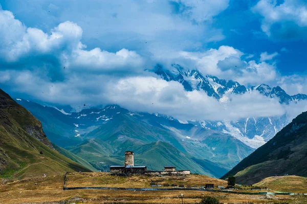 Pueblo Ushguli paisaje con enormes montañas rocosas — Foto de Stock