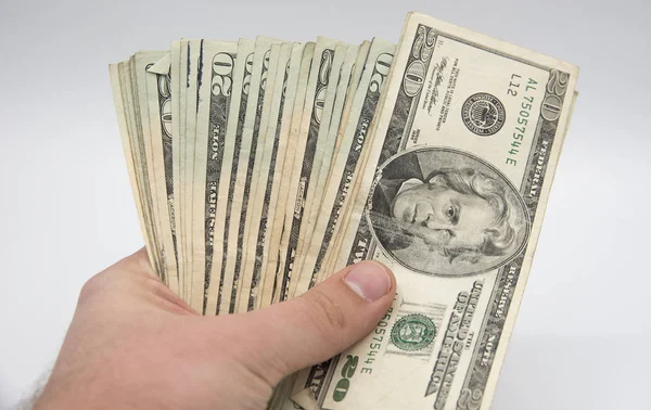Mano sosteniendo dinero, billetes americanos de veinte dólares en un bac blanco — Foto de Stock