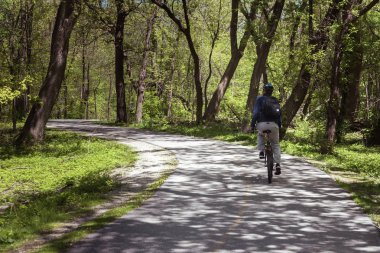 Adam bir park sokakta bir bisiklet sürüş