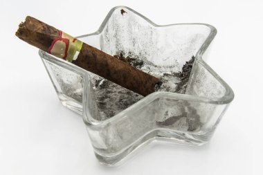 Beyaz zemin üzerinde bir puro ile kül tablası