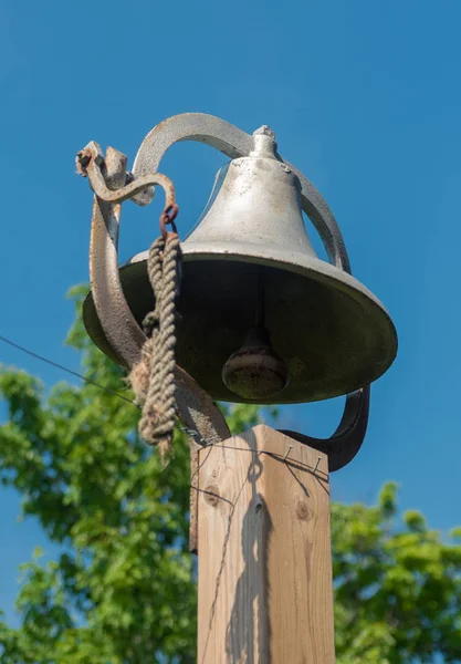 Большой металлический колокол на деревянном столбе — стоковое фото