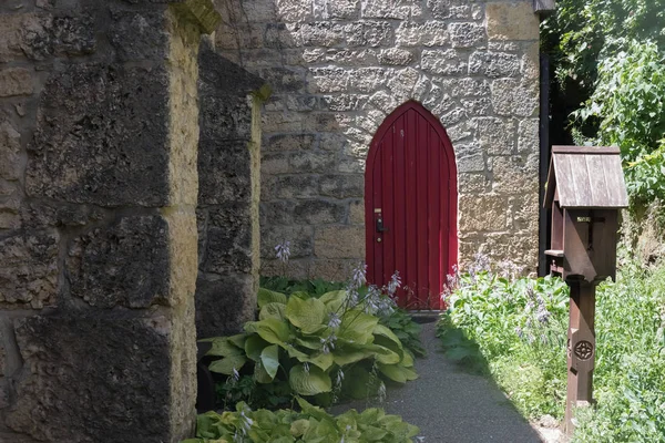 Große rote Tür einer alten Steinkirche — Stockfoto