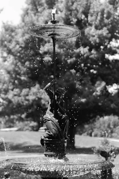 Mujer fuente pequeña con un paraguas — Foto de Stock