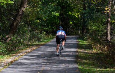 Bir sonbahar parkta Bisiklete binmek adam