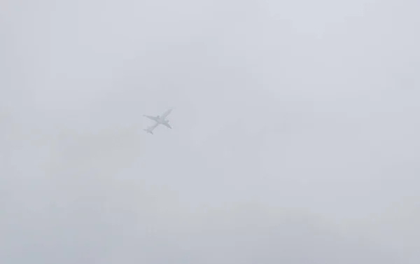 Grote vliegtuig boven de wolken in de lucht — Stockfoto