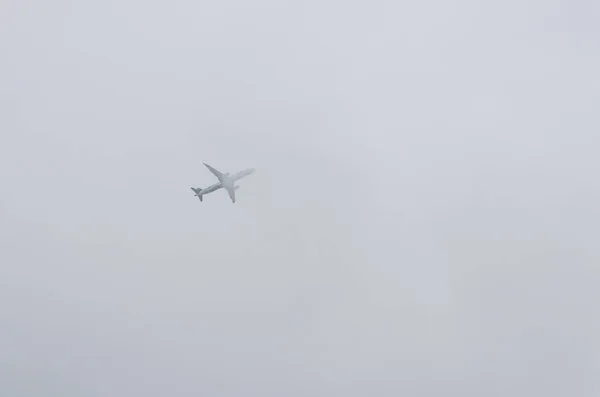 Gökyüzündeki bulutların üzerinde büyük uçak — Stok fotoğraf