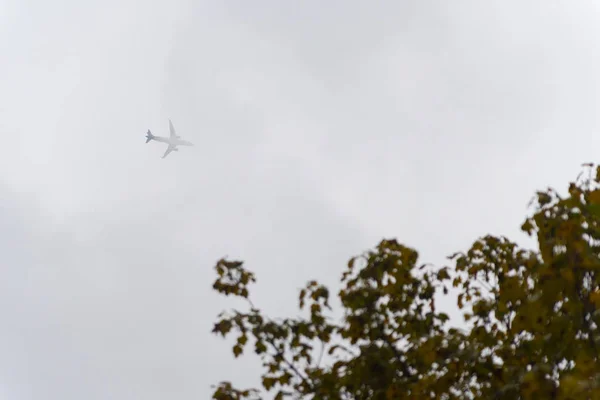 Grand avion au-dessus des nuages dans le ciel — Photo