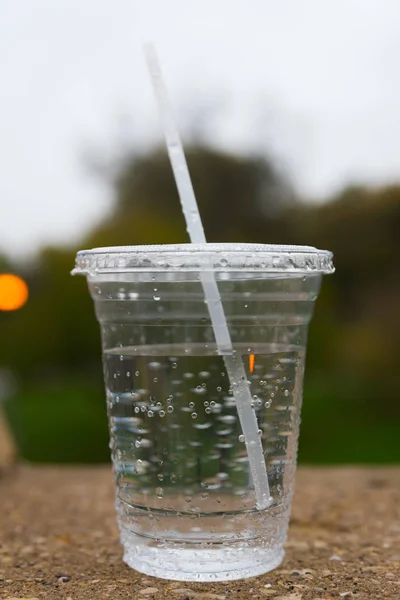 물로 채워진 빨대가 있는 플라스틱 컵 — 스톡 사진