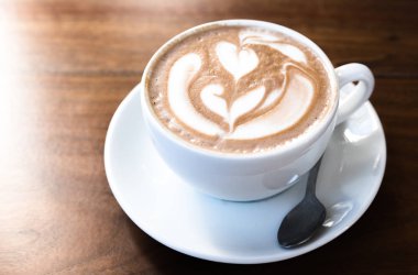 Ahşap masa üzerinde beyaz bir fincan kahve