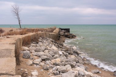 Soğuk bir kış gününde kayalara çarpan göl suyu