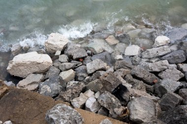 Soğuk bir kış gününde kayalara çarpan göl suyu