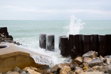 Soğuk bir kış gününde kayalara çarpan göl suyu