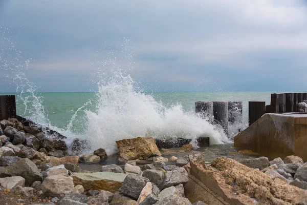 Agua del lago golpeando las rocas en un frío día de invierno —  Fotos de Stock