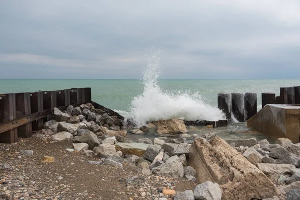 Agua del lago golpeando las rocas en un frío día de invierno —  Fotos de Stock