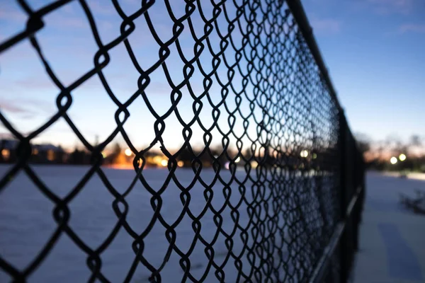 Cerca metálica borrosa en el parque suburbano en un día de invierno — Foto de Stock