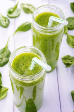 Sağlıklı yeşil kokteyl, ıspanak ve brokoli Beyaz ahşap zemin üzerinde bir cam bardak ile smoothies