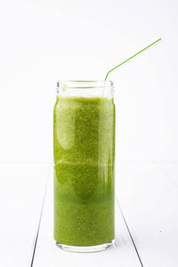 Sağlıklı yeşil kokteyl, ıspanak ve brokoli Beyaz ahşap zemin üzerinde bir cam bardak ile smoothies