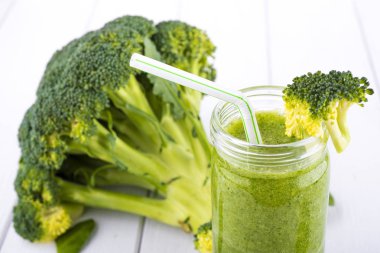 Sağlıklı yeşil kokteyl, ıspanak ve brokoli Beyaz ahşap zemin üzerinde bir cam bardak ile smoothies