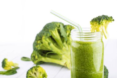 Sağlıklı yeşil kokteyl, ıspanak ve brokoli Beyaz ahşap zemin üzerinde bir cam bardak ile smoothies