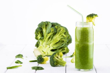 Sağlıklı yeşil kokteyl, ıspanak ve brokoli Beyaz ahşap zemin üzerinde bir cam bardak ile smoothies