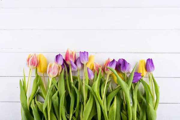 Bunte Tulpen auf einem Holztisch. Ansicht von oben mit Kopierraum — Stockfoto